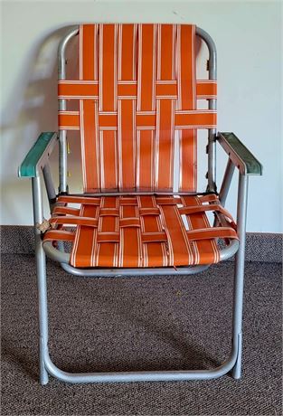 Vintage orange webbed folding chair with rounded leg corners